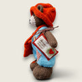 Left side view of Thorne Ash, a hand-knitted Pebblewood collectible bear wearing blue dungarees, rust hat and satchel.