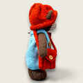 Right view of Thorne Ash Pebblewood collectible bear showing his hand-knitted blue dungarees, rust hat and satchel.
