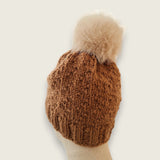 Back view of the toffee hat, showing the textured stitch and pompom