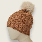 Side view of the toffee textured hat, showing the leatherette tag at the brim