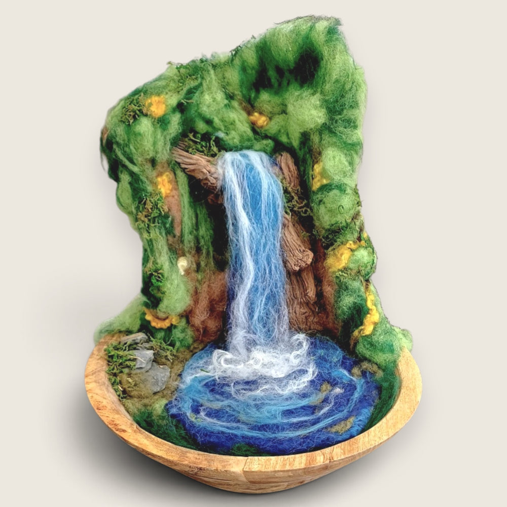 Three-dimensional needle felted waterfall sculpture in a wooden bowl, handmade in Ireland using natural wool fibres, driftwood, moss and stone details.