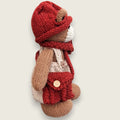 Willow Hearth Permanent Resident shown from the right side, with hand-knitted cream dungarees, rust-red accessories and satchel.